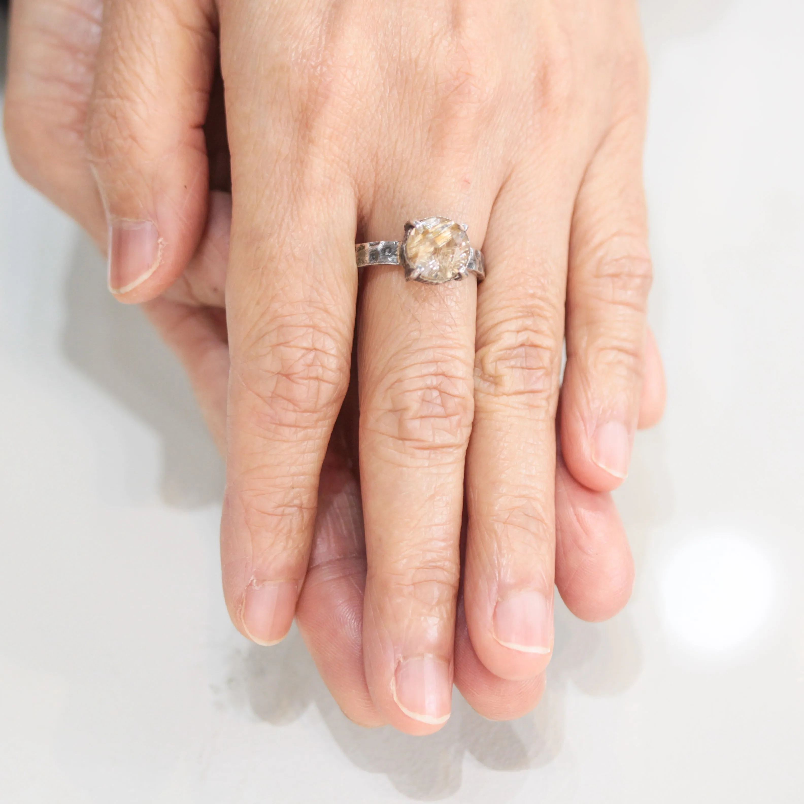 Round faceted golden rutilated quartz ring in silver bezel and prongs setting with sterling silver texture oxidized band